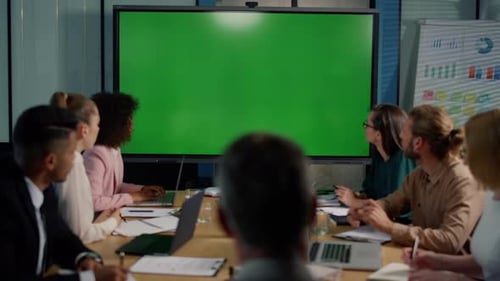 Multi Ethnic Business Team Looking at Presentation on Big Tv with Green
