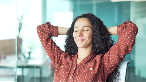 Young employee relaxing at workplace in office job done Satisfied worker leaning back businesswoman