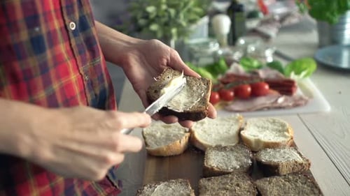 Femme étalant du beurre sur du pain dans la cuisine