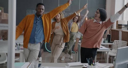 Group of Overjoyed Businesspeople Dancing Laughing Having Fun in Creative Office