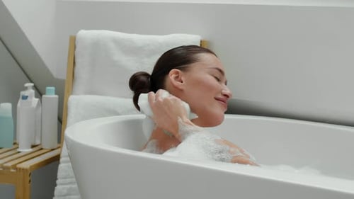 Woman relaxes in bubble bath, self-care