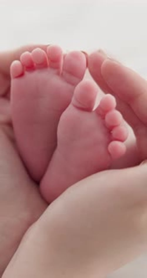 Infant Feet Being Held by Parent Close Up