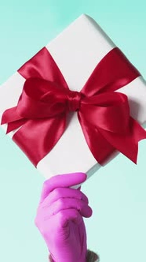 Hand Holding Gift Box with Red Bow