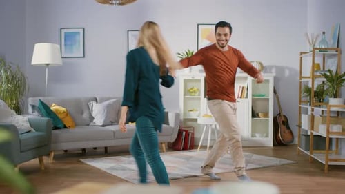 Couple Dancing and Twirling Together in Living Room