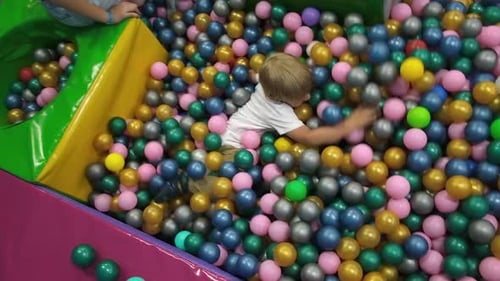 Frère et sœur jouant dans une fosse à balles colorée, terrain de jeu intérieur, piscine à balles pour enfants