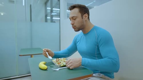 Sporty Man Eating Healthy Salad After Workout at Gym Cafe - slow motion