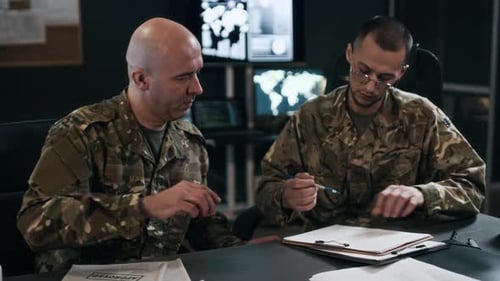 Two Military Officers Signing Documents in Command Hub