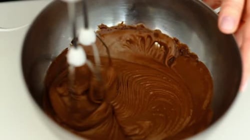 Electric Mixer Mixing Chocolate in Silver Bowl