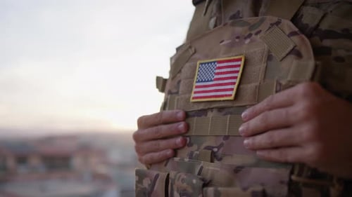 Soldier With US Flag Patch Stands At Sunset