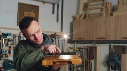 Ein Schreiner überprüft ein Schneidebrett, das er aus Holz gefertigt hat