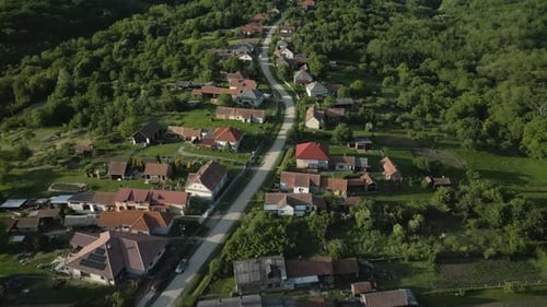 Aerial view of a winding road passing through a small village in a rural area