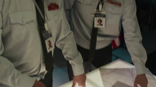 Military Personnel Reviewing Maps in Office