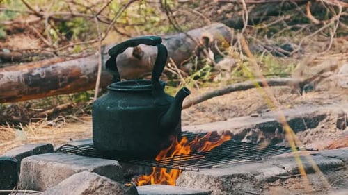 Vieille bouilloire debout sur un feu de camp touristique dans la nature