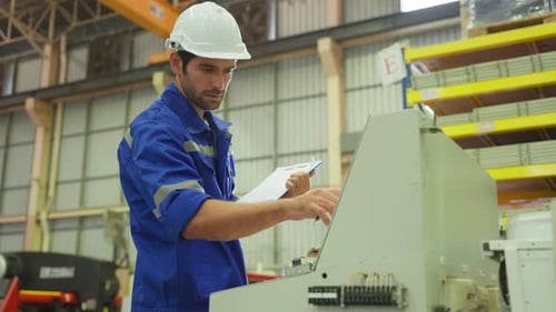 Caucasian handsome male industrial worker work in manufacturing plant.