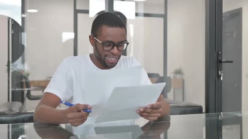 Person Smiling While Reviewing Office Documents