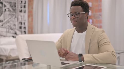 Young Adult on Video Call with Laptop Indoors