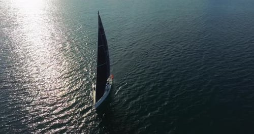 White Modern Sailing Yacht in Blue Warm Water A View From a Drone of a Ship with a Sail Plowing the