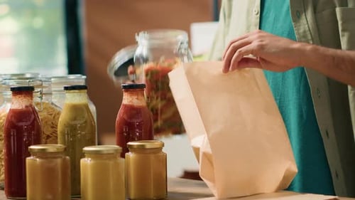Cliente que agrega pasta en una bolsa de papel