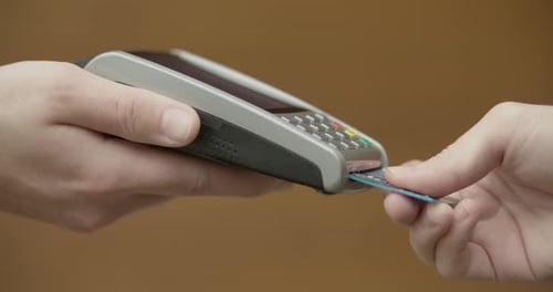 Hand Swiping Credit Card in a Payment Terminal