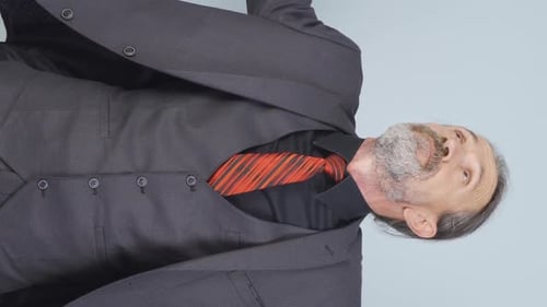 Senior Man in Suit Shrugs and Crosses Arms
