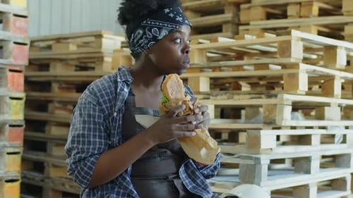 Black Woman Having Lunch at Warehouse between Work
