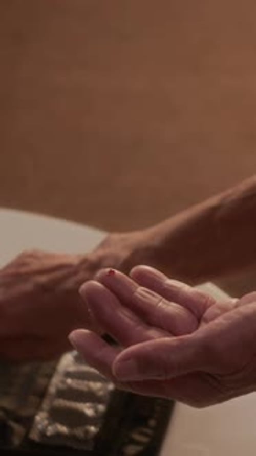 Close-Up of Senior's Hands Checking Blood Sugar