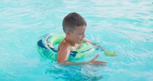 Funny Happy Child Boy in Swimming Pool on Inflatable Rubber Circle Ring