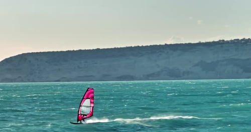 Scenic Air View of Windsurfing Sailboard Riding Waves in Active Sea Sports