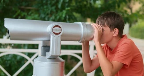 Boy Observing Through Binoculars in Park Setting