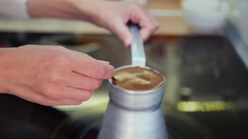 Closeup of a Young Woman Preparing Aromatic Coffee at Home Using a Traditional Cezve