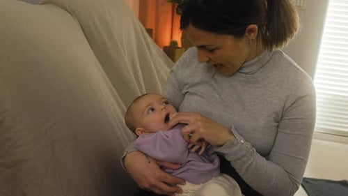 Mother Cradling Infant in Home Setting