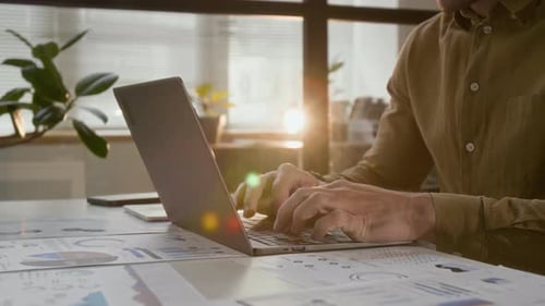 Man Typing on Laptop in Office Setting