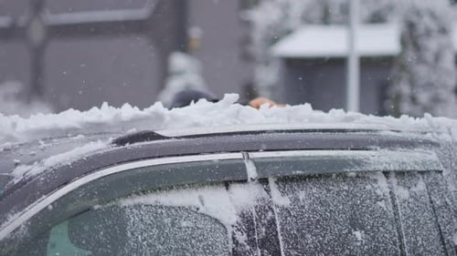 Removing Snow from Car after Winter Storm