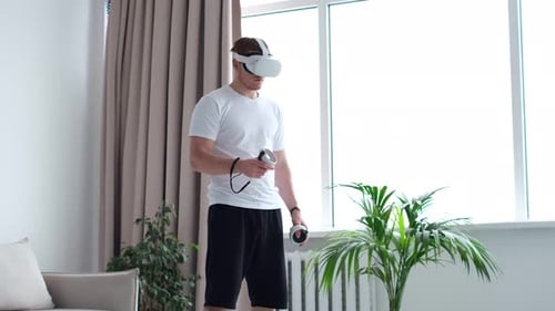 Young Adult Using VR Headset with Controllers