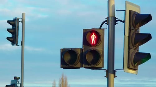Red Pedestrian Traffic Light Glowing Against Blue Sky While Urban Safety System Operating Street