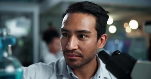 Scientist Analyzing Sample Under Microscope in Laboratory
