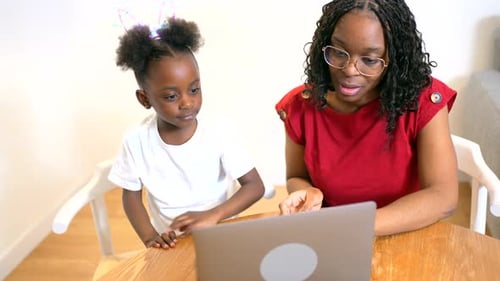 Child and Woman Using Laptop Together