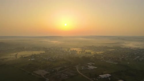Aerial View Foggy Sunrise Over Residential Houses in Suburban Rural Area