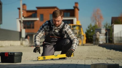 Man Leveling New Paving Stones