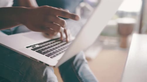 Man, laptop and hands typing email on sofa for communication, research or networking at home