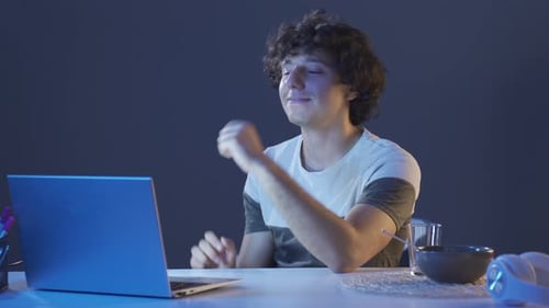 Man Video Chats on Laptop at Night