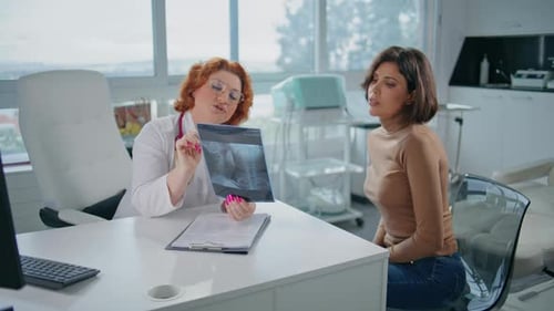 Healthcare Specialist Explaining Xray Picture to Patient in Modern Clinic