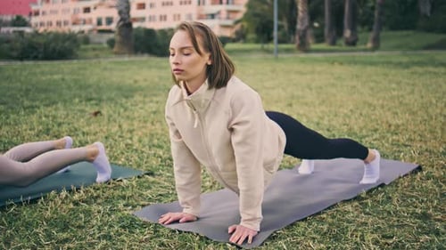 Yogi Girls Stretching Body At Green Park. Relaxed Flexible Fitness Women Performing Asana Practic...