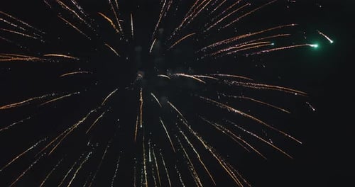 Fireworks Burst Across the Night Sky with Glowing Sparks and Bright Trails During a Festive
