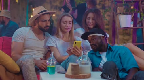 Friends Looking at a Cell Phone at a Party