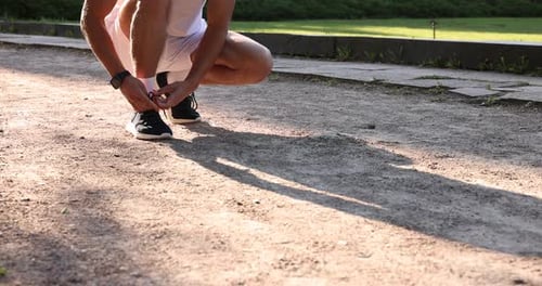 Man tying shoelaces before running outdoors, closeup