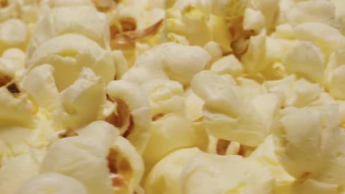 Making Popcorn on Black Pan Closeup Macro Corn Kernels are Popping and Cooking Snack Food