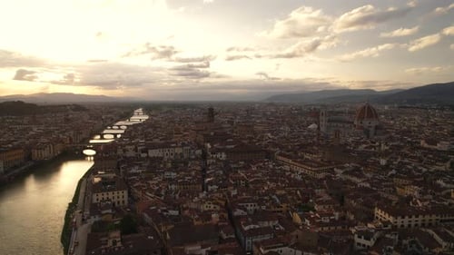 Aerial flyover of Arno River and skyline of Florence old town, Italy