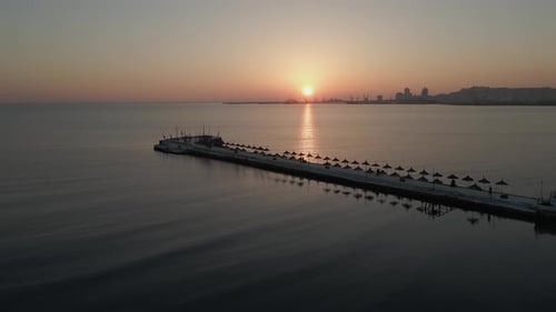 Adriatic sunset aerial of jetty and distant port in Durres, Albania