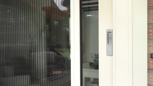 Closing the sliding door of a home from the outside.